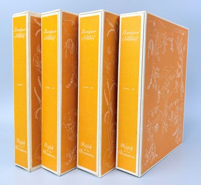 trois livres sont alignés les uns à côté des autres sur une surface bleue
