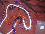 collier de perles violettes et blanches, avec des perles orange et blanches et un téléphone portable
