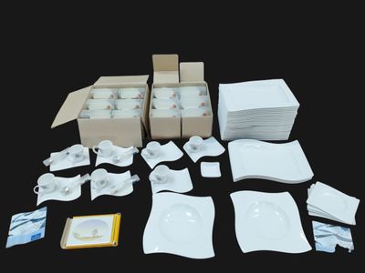 beaucoup d'assiettes et de tasses blanches sur la table