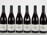 six bouteilles de vin sont alignées sur une table