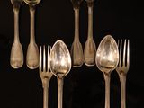 six cuillères en argent et six cuillères en argent posées sur une table noire