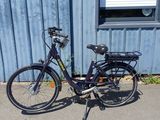 a black bike parked in front of a blue building