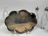 three glass vases and a silver tray on a table