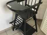 une chaise haute noire avec un plateau dessus