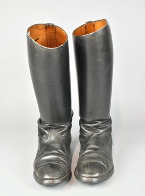 une paire de bottes argentées posées sur une surface blanche, sur fond blanc