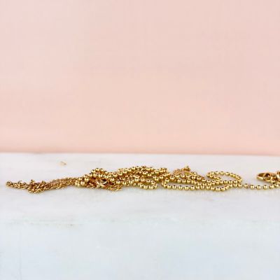a gold chain bracelet with a tiny bead on it