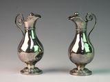 pair of silver vases with handles on a white surface