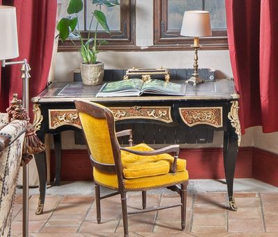 une chaise jaune placée devant un bureau sur lequel se trouve une lampe
