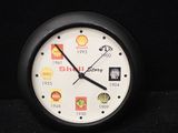 une horloge noire avec un cadran blanc et divers autocollants dessus