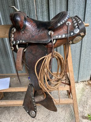 a saddle that is sitting on a wooden bench