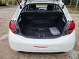 the back of a white car with its trunk open and luggage in the trunk