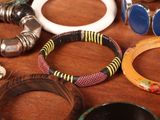 many different bracelets and rings on a table