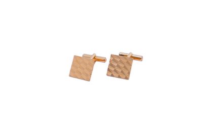 a close up of a pair of gold cufflinks on a white background