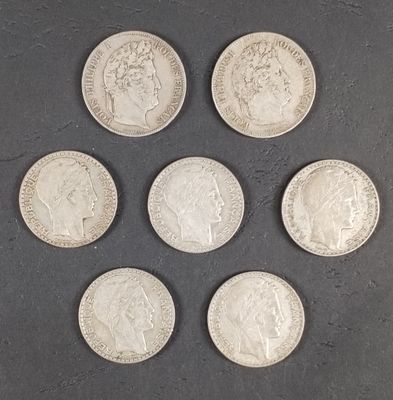 six pièces de monnaie britanniques différentes sont disposées en cercle sur une surface noire