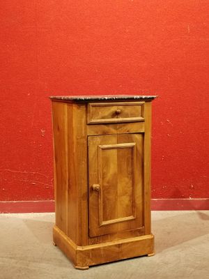une petite armoire en bois posée au sol, avec un plateau en marbre