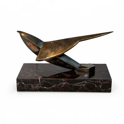 sculpture en bronze représentant un oiseau, posée sur un socle en marbre, sur fond blanc