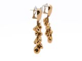gold plated earrings with dangling leaves on them against a white background
