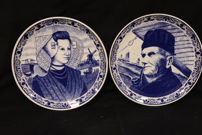 two blue and white plates with portraits of men and women on them