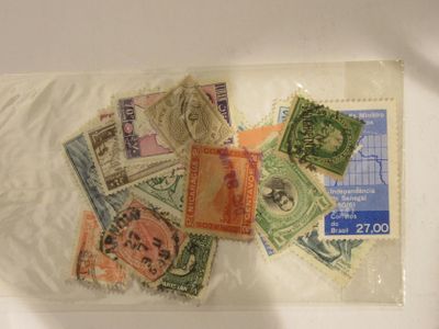de nombreux timbres différents dans un sachet transparent posé sur une table