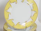 yellow and white plates stacked on top of each other on a white surface