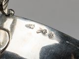a close up of a silver plate with a bird on it