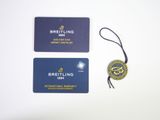 two business cards with a tag attached to them sitting on a table