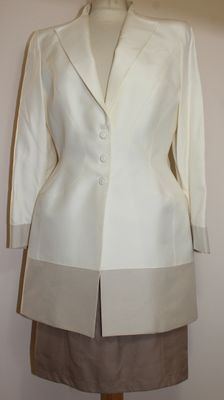 une veste blanche sur un mannequin, avec une jupe marron