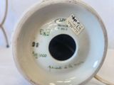 a close up of a white porcelain vase with a sticker on it