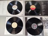 three black vinyl records are on display on a table
