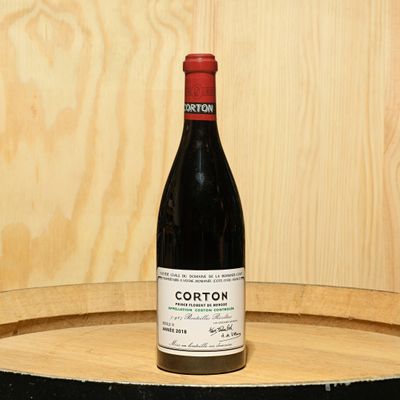 a bottle of wine sitting on top of a barrel