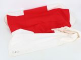 a red and white flag laying on top of a white table