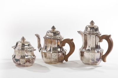 three pieces of silver tea and coffee set on a white surface