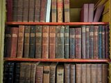 de nombreux livres anciens rangés sur une étagère d'une bibliothèque