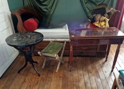 une petite table sur laquelle est posé un ours en peluche, dans un coin de la pièce