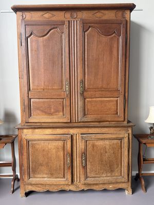 une photo d'une armoire en bois à deux portes, surmontée d'une lampe