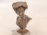 buste en bronze représentant une femme coiffée d'un chapeau et tenant un livre