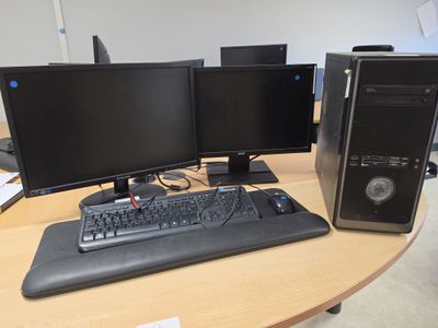 two computer monitors and a keyboard on a desk