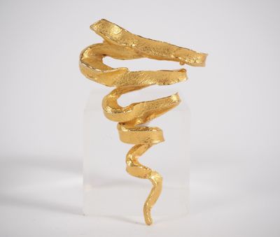 a gold snake sculpture on a clear base with a white background