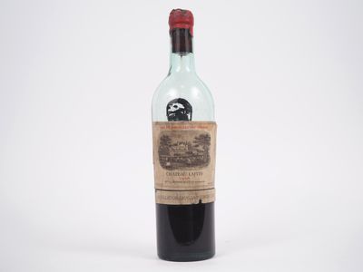 une vieille bouteille de vin posée sur une surface blanche