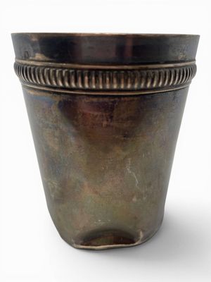a metal pot that is sitting on a white surface