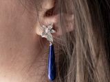 a close up of a woman ' s ear wearing a pair of earrings