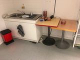 a small kitchen with a sink, stove, and shelves