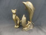 deux figurines en or représentant un chat et un dauphin