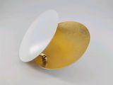 a gold plate with a white lid on a white surface
