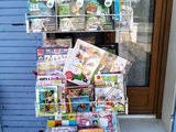 un chariot chargé de magazines devant un magasin