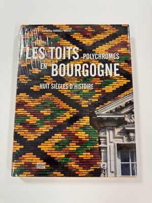a close up of a book on a table with a building in the background
