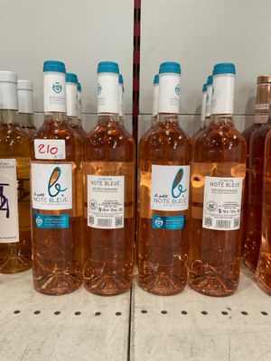 bottles of wine are lined up on a shelf in a store