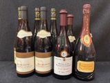 six bouteilles de vin sont alignées sur une table