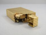 une photo d'un briquet doré posé sur une table blanche