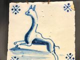 a picture of a blue and white tile with a picture of a giraffe on it